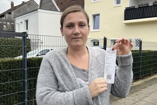 Antonia Plotek hält einen Strafzettel hoch.