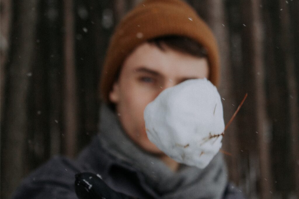 junger mann wirft einen schneeball
