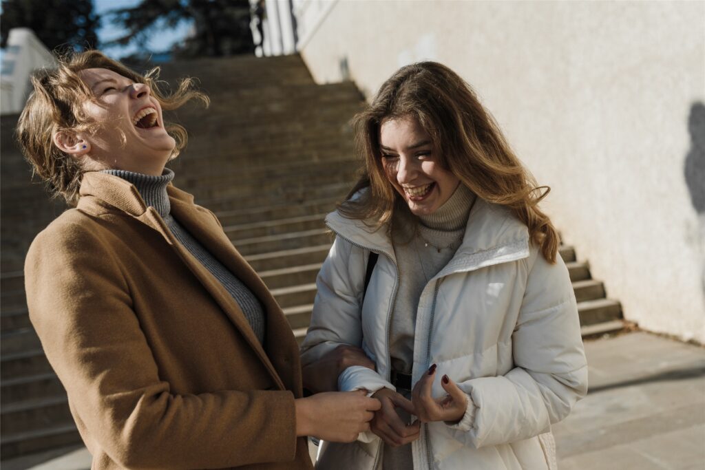 zwei frauen lachen zusammen
