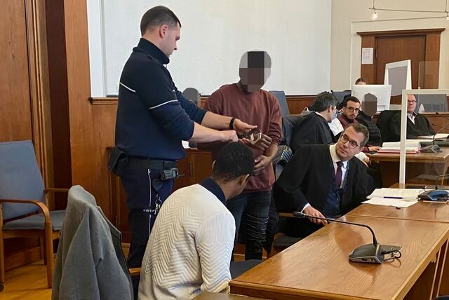 Die Angeklagten mit ihren Anwälten und einen Justizdiener vor dem Landgericht in Dortmund
