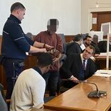 Die Angeklagten mit ihren Anwälten und einen Justizdiener vor dem Landgericht in Dortmund