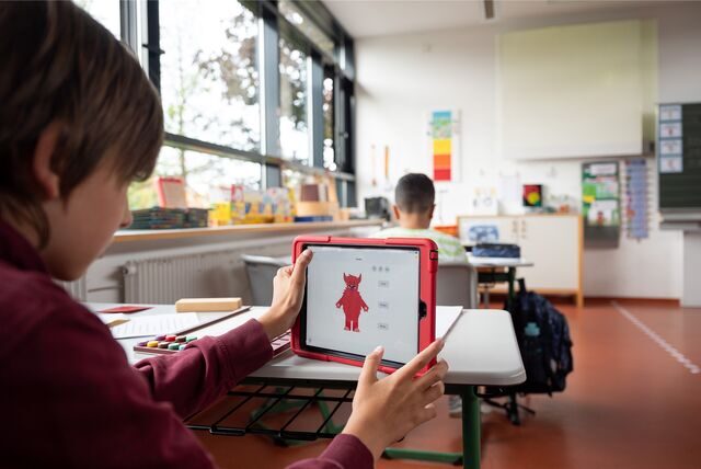 Ein Schüler mit einem Tablet im Klassenraum