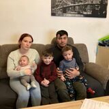 Eine Mutter und ein Vater sitzen mit ihren drei kleinen Söhnen auf einer Couch in ihrer Wohnung in Recklinghausen im Stadtteil Grullbad.