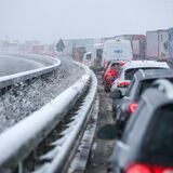 Autos bremsen an einem Stauende auf der verschneiten Autobahn 72.