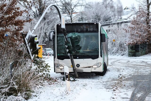Ein Schulbus steht auf schneeglatter Straße in einer Ampel. Diese hat die Frontscheibe zertrümmert.