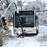 Ein Schulbus steht auf schneeglatter Straße in einer Ampel. Diese hat die Frontscheibe zertrümmert.