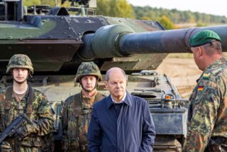 Bundeskanzler Olaf Scholz (SPD, 2.v.r) lässt sich vor der Ausbildungs- und Lehrübung des Heeres im Landkreis Heidekreis in der Lüneburger Heide den Kampfpanzer «Leopard 2» der Bundeswehr erklären.