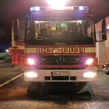 Zu sehen ist ein Feuerwehrauto bei Nacht.