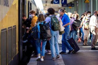 Reisende betreten an einem Bahnsteig im Hauptbahnhof Hannover eine Regionalbahn.