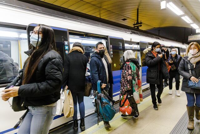 Mehrere Personen mit Maske steigen in Madrid auf dem Bahnsteig .