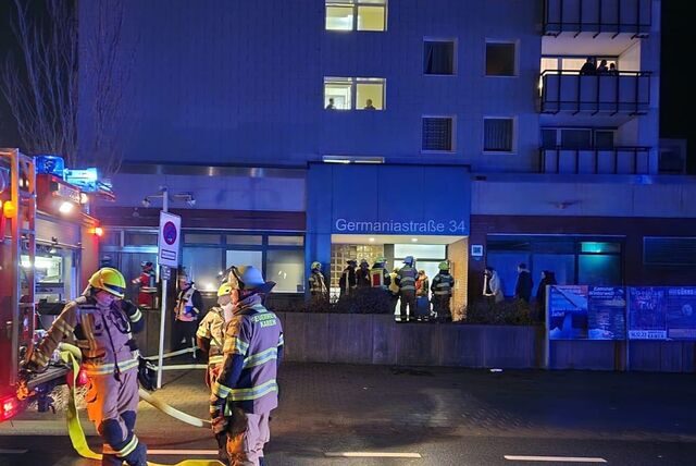Feuerwehrleute vor dem Hochhauskomplex, in dem sich auch der Methleraner Rewe-Markt befindet.