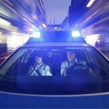 Poiizisten in einem Polizeiauto