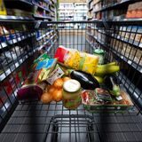 Verschiedene Lebensmittel liegen in einem Supermarkt in einem Einkaufswagen.