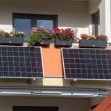 Zwei Solarmodule hängen an einem Balkon.