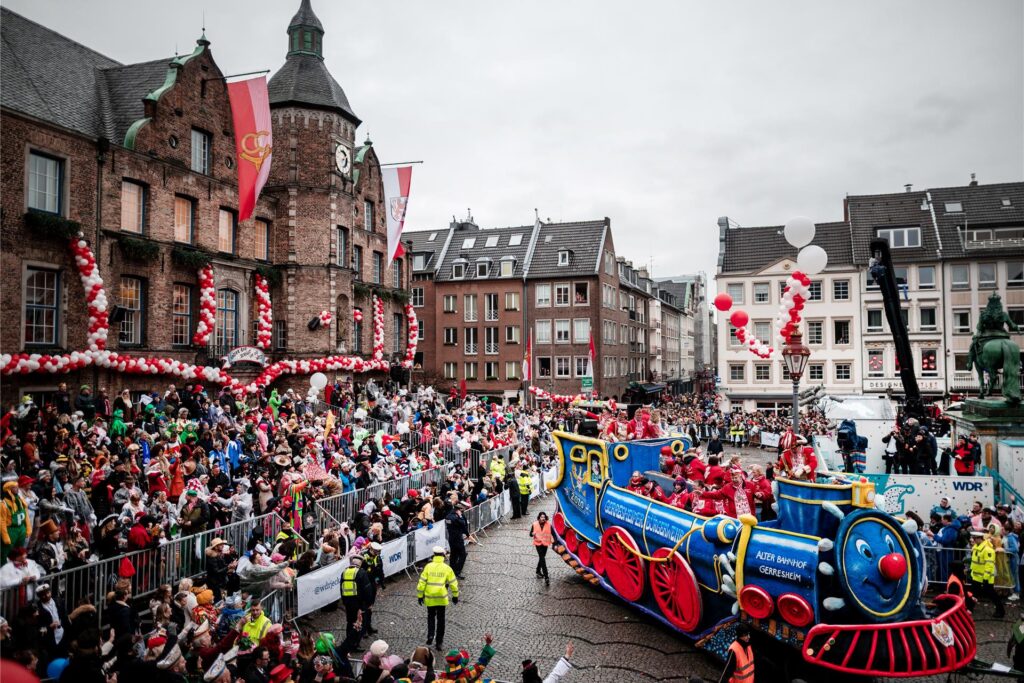 Ein Wagen fährt beim Rosenmontagszug in Düsseldorf am Rathaus vorbei.