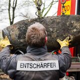 Ein Bombenentschärfer lädt einen Blindgänger auf einen Transporter.