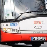 Menschen steigen in einen Bus ein.