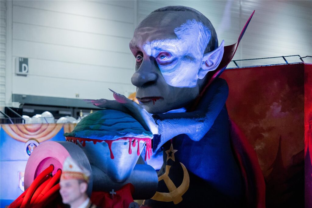 Ein Mottowagen, der Russlands Präsidenten Wladimir Putin zeigt, wie er die Welt durch den Fleischwolf dreht, wird beim Richtfest für den Kölner Rosenmontagszug in der Koelnmesse vorgestellt. Ein Mottowagen, der Russlands Präsidenten Wladimir Putin zeigt, wie er die Welt durch den Fleischwolf dreht, wird beim Richtfest für den Kölner Rosenmontagszug in der Koelnmesse vorgestellt.