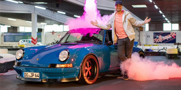 JP Kraemer vor blauem Auto und Feuerwerk