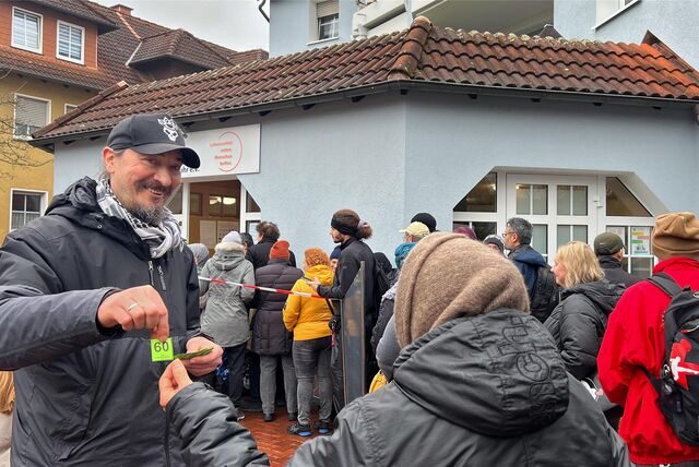 Holger van de Pol hilft nicht nur beim Abholen der Lebensmittelspenden, sondern gibt auch Nummern an die Wartenden vor der Fröndenberger Tafel aus.