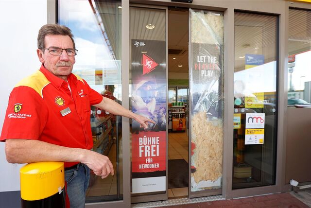 Thomas Kolkmann, Pächter der Tankstelle im Kamen-Karree, zeigt die beschädigte Eingangstür, die mit einem Gullydeckel zerschmettert wurde. Er hat sie erst einmal notdürftig repariert.