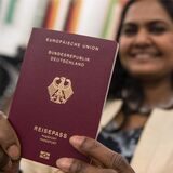 Mridula Singh, die aus Indien stammt, hält am 23.01.2018 nach der Einbürgerungsfeier für mehr fast 2200 Menschen in der Paulskirche in Frankfurt am Main (Hessen) ihren Pass in die Kamera.