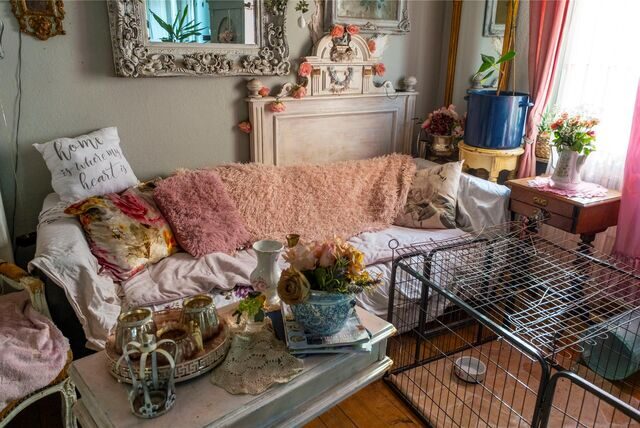 Ein Blick ins Wohnzimmer des Hauses. Zu sehen sind ein Sofa, ein Hundegehege und zwei reich dekorierte Beistelltische.