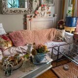 Ein Blick ins Wohnzimmer des Hauses. Zu sehen sind ein Sofa, ein Hundegehege und zwei reich dekorierte Beistelltische.