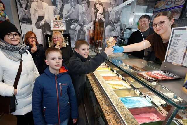 Die Eisdiele „Eistreff” ist schon gut besucht. Hier überreicht Aliyah Klotz Phillip (12) sein Eishörnchen.