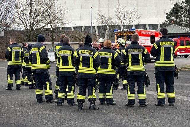 Feuerwehrleute stehen vor dem Kraftwerk in Heil.