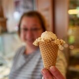 Eine Frau hält eine Eistüte in die Kamera