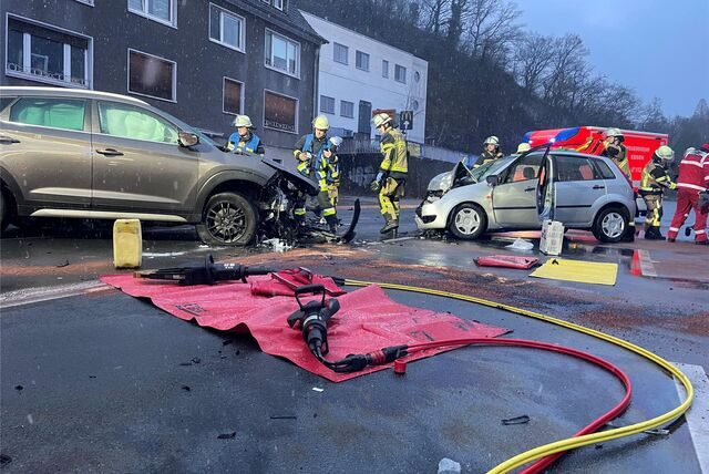 Der Blick auf eine Unfallstelle in Essen. Feuerwehrmänner begutachten zwei frontal ineinander gefahren Autos.