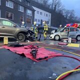 Der Blick auf eine Unfallstelle in Essen. Feuerwehrmänner begutachten zwei frontal ineinander gefahren Autos.