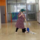 Eine Frau wischt den Boden in einer Schule