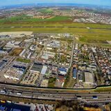Dieses Bild zeigt am unteren Rand die B1, darüber das Gewerbegebiet Eco Port und den Flughafen mitsamt Landebahn.