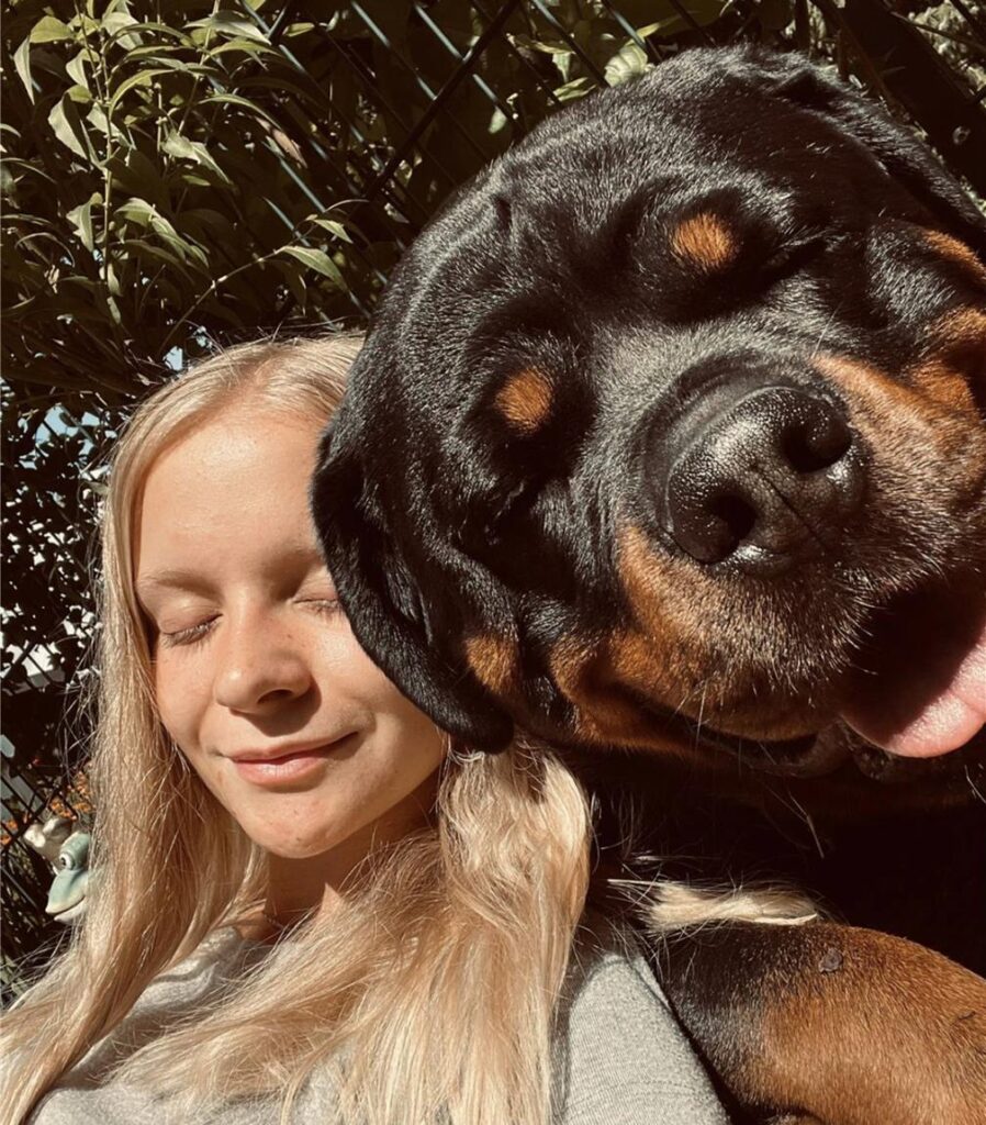 Zu sehen ist eine blonde Frau mit ihrem Hund.
