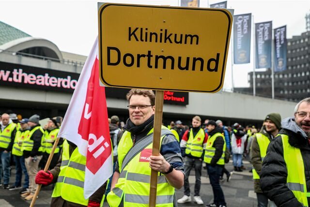 „Klinikum Dortmund“ steht auf einem Schild, das ein Mann hochhält.
