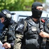 Maskierte Polizisten eines Sondereinsatzkommandos sichern am 11.07.2014 in Asbach-Bäumenheim (Bayern) ein Grundstück.