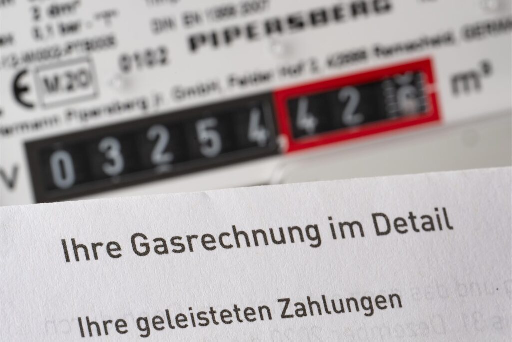 Eine Gasrechnung wird in einem privaten Haushalt vor einem Gaszähler gehalten (gestellte Szene). Eine Gasrechnung wird in einem privaten Haushalt vor einem Gaszähler gehalten (gestellte Szene).