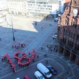 Mit roten Schirmen formen die Menschen „18 %“ auf dem Dortmunder Friedensplatz.
(Archiv)