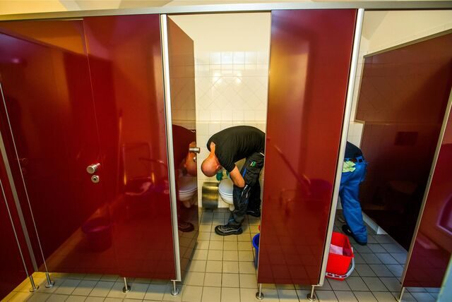 Reinigungskräfte säubern Toiletten.