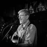Zu sehen ist Johannes Diehl, der Gitarre spielt und singt.