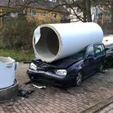 Die zerbrochene Litfaßsäule liegt auf einem Auto.