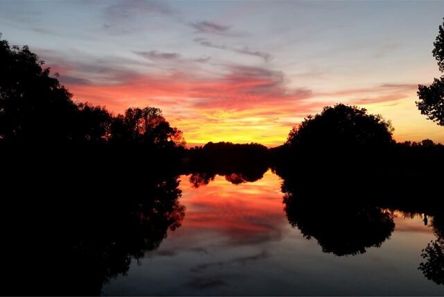 Zu sehen ist ein wunderschöner Sonnenuntergang, der sich in der Ruhr spiegelt.