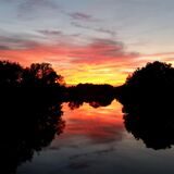 Zu sehen ist ein wunderschöner Sonnenuntergang, der sich in der Ruhr spiegelt.