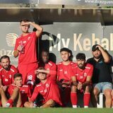 Spieler von Türkspor auf der Ersatzbank: Die Sonne scheint, mehrere halten sich eine Hand vor das Gesicht.