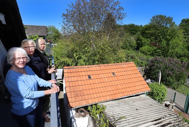 Ursula Dörr (Mitte) steht im Mai 2019 auf ihrem Balkon mit ihren Nachbarinnen Elisabeth Grothaus (vorn) und Silvia Schön. Das Pfeifensignal der Regionalbahn 54 nervte die Anwohner an der Bahnlinie massiv.