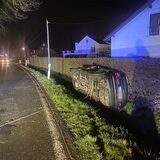 Ein Auto liegt in Fröndenberg im Straßengraben auf der Seite.