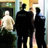 Polizisten stehen im Eingang der Einrichtung.