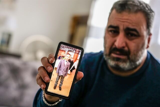 Fadi El-Jaddou aus Recklinghausen hält ein Handy in die Kamera, auf dessen Display sein Sohn Amir zu sehen ist. Der Junge trägt einen Anzug mit Fliege.